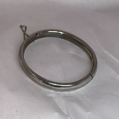 Vintage Silver Cuff Bangle Bracelet With Chain Catch. This Bracelet Measures 8 1/2" In Diameter, And 2 1/2" Across Once Closed. It Is 4.96mm Thick And 8.45mm Wide. This Bracelet Weighs 18.22 Grams. This Bracelet Has A 2 3/4" Chain Catch. Silver Nickel-free Bangle, Silver Stainless Steel Bangle With Polished Finish, Classic Round Metal Bangle, Silver Metal Cuff Bracelet, Jubilee Style, Classic Nickel-free Round Bangle, Classic White Gold Metal Bangle, Formal Silver Stainless Steel Bangle, Nickel-free Silver Bangle Cuff Bracelet, Silver Stainless Steel Round Cuff Bracelet