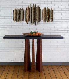 a table that has some fruit on it in front of a white brick wall and wooden floor