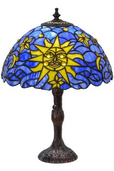 a table lamp with a blue and yellow sun on it's face, sitting on top of a white surface