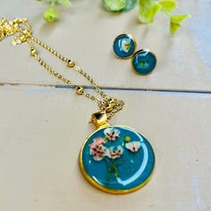 Make gifting easy! I have put together a really pretty set of handmade treasures. This necklace and earring set is handmade and assembled by me and made to order. 1-5 day shipping. I use resin, watercolor paint, watercolor paper, and flowers. I also use mustard seeds. They tend to resemble a sun but they represent faith in Jesus.  Necklace and earring set is 18 karat gold plated. Necklace length offered in (16, 18, 20 inch). ☀️ Your order will automatically be gift wrapped. All earring and neckl Blue Flower Charm Jewelry As Gift For Her, Personalized Blue Bohemian Jewelry, Handmade Dangle Jewelry Sets For Gifts, Handmade Green Pendant Jewelry Sets, Green Handmade Pendant Jewelry Sets, Bohemian Turquoise Jewelry Sets For Gifts, Turquoise Round Pendant Jewelry Gift, Turquoise Round Pendant Jewelry As Gift, Round Jewelry Sets For Mother's Day Gift