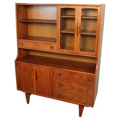 a wooden cabinet with glass doors and drawers