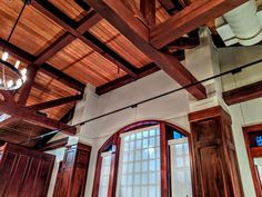 an open room with wooden beams and two chandeliers hanging from it's ceiling