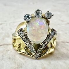 CLEARANCE - 40% OFF! Beautiful vintage 18 karat yellow and white gold ring featuring a fine natural opal cabochon, the birthstone for October ! The gemstone weighs approximately 2 carats, and is surrounded by 12 diamonds weighing approximately 0.30 carat.Diamonds are approximately G-H color SI-I1 clarity. Weighs 7.6 grams. Size 7.25 US / O 1/2 UK / 55 FR. > Ring sizing not included.This ring can be sized to fit most fingers.If you need to size this ring, please contact us before placing the orde Edwardian Style Engagement Ring, Smoky Quartz Jewelry, Gold Opal Ring, Gemstone Rings Vintage, December Birthstone Jewelry, Gold Chain Earrings, Opal Diamond Ring, Statement Rings Diamond, Citrine Jewelry