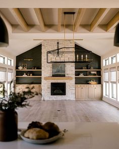 a large open living room with fireplace and built in shelves