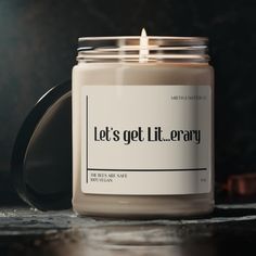 a candle with the words let's get lit library printed on it