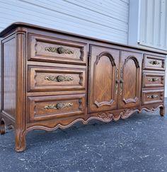 an old wooden dresser with ornate carvings on it