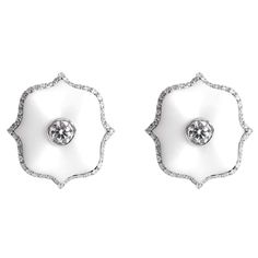 A pair of platinum Mini Lotus ear clips each centered upon a round brilliant-cut colorless diamond set in matte white ceramic with a colorless diamond micropavé surround. Exquisite White Diamond Earrings For Evening, Luxury Diamond White Earrings With Pave Setting, Luxury White Earrings With Single Cut Diamonds, White Luxury Earrings With Single Cut Diamonds, Luxury White Earrings With Pave Setting, Luxury White Pave Set Earrings, Luxury Platinum Earrings With Single Cut Diamonds, Luxury White Diamond Platinum Earrings, Luxury White Platinum Diamond Earrings