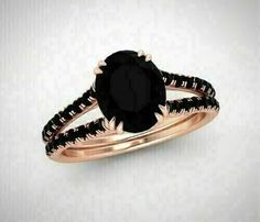 a black diamond engagement ring set on top of a white background with the center stone in rose gold