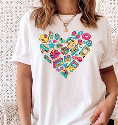 .:Description:. This 80's or 90's nostalgia, vibe heart retro graphic tee is a perfect gift for your favorite millennial, 1980's baby, 1990's baby or to add to your own collection. If you need an 80's or 90s theme party outfit, this t-shirt is perfect! Unisex, light weight, loose fit, soft material and high quality t-shirt. Sleeves are rolled for styling purposes. .:This is a direct to garment item meaning a high quality, water soluble ink is used. The ink is stretchy, durable and can be washed 90s Theme Party Outfit, I Love The 90s, 90s Theme Party, Love The 90s, 90s Theme, 90s Party, Retro Graphic Tees, 90s Baby, 90s Shirts