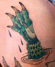 a tattoo on the back of a woman's shoulder with an image of a green plant