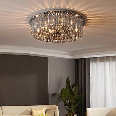 a living room filled with furniture and a large chandelier above the couches