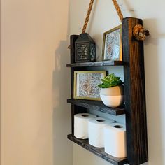 a wooden shelf holding two rolls of toilet paper