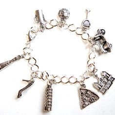 This charm bracelet features Italy/Italian inspired Tibetan silver charm. The charms are attached to a silver tone 7.5 inches chain bracelet Silver Symbolic Bracelets With Dangling Charms, Symbolic Silver Bracelets With Dangling Charms, Silver Metal Chain Bracelet With Dangling Charms, Symbolic Silver Bracelet With Dangling Charms, Symbolic Metal Charm Bracelet With Dangling Charms, Symbolic Silver Bracelets With Charms, Antique Silver Metal Charm Bracelet Gift, Handmade Symbolic Silver Charm Bracelet, Silver Dangle Charms Chain Bracelet