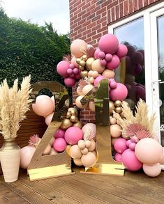 a number made out of balloons sitting on top of a wooden table next to a potted plant