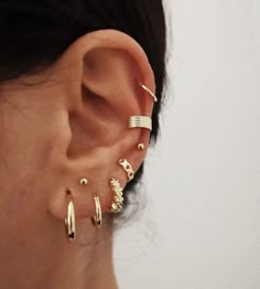 a close up of a person's ear with three different types of piercings