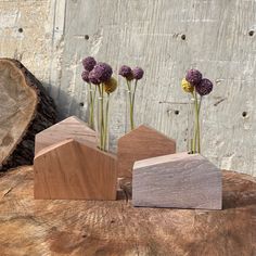 three small wooden blocks with flowers in them