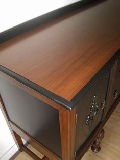 a wooden desk with two drawers sitting on top of it's sideboard in a room