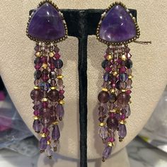 So Gorgeous!!!!! This Is A Pair Of Authentic Chipita Earrings From The 1980s. We Carried The Collection In Our Wearable Art Gallery In Ny And Just Uncovered Several Pieces That Have Been Packed Away After We Moved Locations. These May Be Over 40 Years Old But They Are Brand New. They Are Designer Stamped. This Pair Is Beautiful. It Features Genuine Amethyst Semi Precious Stones And Amethyst Cut Crystals. There Are Gold Crystal Accent Beads. These Are 4” Long And Clip On Style Earrings Signed Sto Vintage Amethyst Purple Earrings, Bohemian Purple Dangle Crystal Earrings, Purple Bohemian Chandelier Earrings For Party, Bohemian Purple Chandelier Earrings For Party, Elegant Purple Crystal Earrings With Dangling Beads, Purple Bohemian Crystal Earrings, Handmade Bohemian Purple Crystal Earrings, Handmade Purple Amethyst Chandelier Earrings, Handmade Purple Bohemian Crystal Earrings