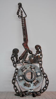 a metal object with chains attached to it's sides and a wrench hanging from the side