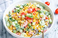 a white bowl filled with corn salad next to silverware