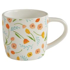 a white coffee cup with orange and blue flowers on it