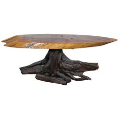 a wooden table with a metal base and tree roots on the top, against a white background