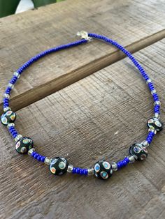 a blue beaded necklace on a wooden table