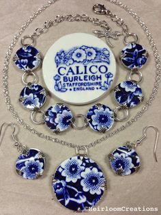 a blue and white flowered necklace with matching earring set on a silver chain