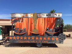 a truck with an orange curtain and a statue on the back that says, freshman walk of fame