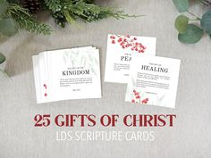 the 25 gifts of christ cards are on display with greenery and pine cones in the background