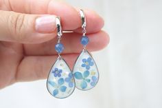 "Real flower earrings with kyanite gemstone. Summer gift for those who are dear to us. If you're throwing a garden wedding set against a backdrop of fresh florals and luscious greenery, then these pretty drop earrings are a no-brainer. Floral earrings work for just about everyone and every theme. even better.  Floral statement earrings are one of those accessories you'll get tons of use out of post \"I dos\" as well. ♥ S H I P P I N G ♥ We ship this jewelry to you free of charge throughout the US, carefully and lovingly packaged and tracked. Optionally, we can gift wrap your order, to which we are also happy to add a personal message from you. ♥ P R O D U C T I O N ♥ Each piece is traditionally handcrafted with the highest precision and quality in our studio in Egg Harbor Township, NJ (USA Blue Flower-shaped Jewelry For Her, Blue Flower Charm Jewelry As Gift For Her, Delicate Teardrop Flower Earrings For Anniversary, Elegant Flower Teardrop Earrings For Gift, Elegant Flower Shaped Teardrop Earrings, Elegant Teardrop Earrings With Pressed Flowers, Dainty Blue Earrings For Gifts, Elegant Blue Pressed Flower Earrings, Handmade Elegant Flower Teardrop Earrings