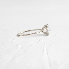 a diamond ring sitting on top of a white surface