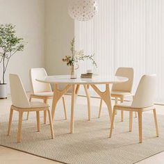 a dining room table with chairs and a vase on the rug in front of it