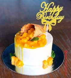 a birthday cake with fruit on top and a happy birthday candle in the middle that says happy birthday