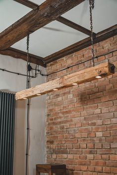 a wooden beam suspended from the ceiling in a brick room with exposed beams and metal bars