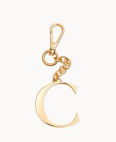 a gold key chain with the letter c hanging from it's center, on a white background