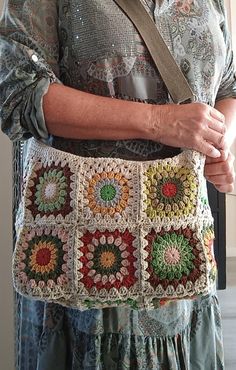 an older woman is holding a crocheted purse