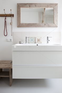 a bathroom with a sink, mirror and bench