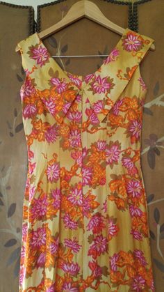 "Gorgeous 70s maxi Hawaiian dress in yellow ochre colour with orange and pink and mustard coloured flower print. The dress is long maxi length with fishtail hem which opens up in the middle between hem curtain. Fitted waist and bust. Collar goes around and over shoulders and ends at the back in two pointed 'collars. Zip up at back. Made by Liberty House, made in Hawaii, Kailua, Downtown Waialae By Hawaiian Casuals arm hole to arm hole 17\" (bust 34) waist 28\", hips 34\", dress length 55\"" Fitted Yellow Dress With Retro Print, Vintage Yellow Floor-length Dress, Retro Yellow Maxi Dress, Retro Floral Print Floor-length Maxi Dress, Vintage Yellow Floral Print Dress, Vintage Orange Floral Print Dress, Yellow Retro Maxi Dress For Spring, Retro Yellow Maxi Dress For Spring, Yellow Retro Maxi Dress