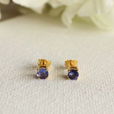 "Gold Round Tanzanite Studs available in 10K, 14K, 18K - Yellow Gold, White Gold, Rose Gold. The eye-catching sparkle of this piece is absolutely breathtaking! Approximate product detail for 18K Gold Earrings (Gold Weight will vary depending on the caratage) Gold Details: -Gold-18K (10K/14K/Silver on demand) -Gold Weight- 1.641 gms Tanzanite (Colored Stone) Details: -Size: 5 MM -Setting- Prong Setting -Tanzanite Weight- 1 cts These Tanzanite Stimulants Stud Earrings are one of a kind. They look Brilliant Cut Tanzanite Gemstones For Gift, Brilliant Cut Tanzanite Gemstones As Gift, Gold Brilliant Cut Gemstones As Gift, Gold Brilliant Cut Gemstones For Gift, Brilliant Cut Gold Gemstones For Gifts, Custom Gold Jewelry, Tanzanite Studs, Blue Gemstone Earrings, December Birthstone Jewelry