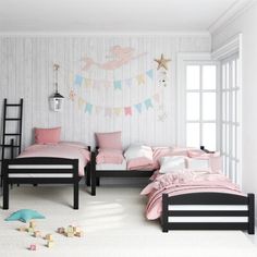 two beds in a room with pink and white decor on the walls, along with toys