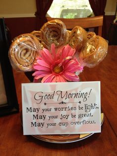 a sign that is on top of a plate with some pastries and flowers in it