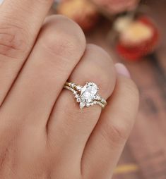 a close up of a person's hand with a diamond ring on their finger