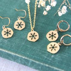 "A delightful collection of winter themed gold plated snowflake jewellery. Choose between a necklace, huggie hoop earrings or earwire earrings. The shiny snowflake charms are lightly textured and are perfect to add that wintery detail to any outfit.  The snowflake charms measure 1cm tall (0.4\"). If you are selecting the necklace option, please also select the chain length you would like from the drop down menu.  All materials are gold plated brass. Delivered to you gift boxed ready to give as a Christmas Jewelry Set As Gift With Matching Earrings, Christmas Jewelry Gift With Matching Earrings, Christmas Jewelry Gift Set With Matching Earrings, Festive New Year Dangle Jewelry, Gold Earrings As Winter Gift, Sterling Silver Jewelry For Winter Gifts, Snowflake Jewelry For Holiday Gifts, Gold Jewelry Christmas Gift For Her, Holiday Dangle Jewelry Gift