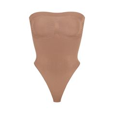 Cinch your waist and sculpt your tummy and core in this perfectly compressive strapless thong bodysuit. Wear it your way with removable adjustable straps that convert to shoulder straps, cross-back, or halter-style. Features center front and side stitching to define and support your bust, and a cotton gusset with snap closure. Fits true to size. | SKIMS Strapless Thong Bodysuit | Medium Neutral | Seamless Sculpt Strapless Shaping Bodysuit With Built-in Bra, Strapless Stretch Shapewear Bodysuit, Seamless Stretch Tube Top, Strapless Shaping Bodysuit Shapewear, Strapless Shaping Bodysuit, Stretch Smoothing Strapless Bodysuit, Strapless Stretch Smoothing Bodysuit, Shapewear Bandeau Bodysuit With Built-in Bra, Strapless Smoothing Stretch Bodysuit