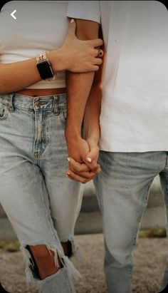 two people holding hands while standing next to each other