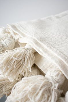 a white blanket with tassels laying on top of it