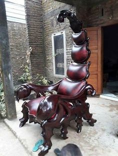 a large wooden chair sitting on top of a sidewalk