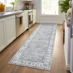 a kitchen with white cabinets and wood flooring next to an oven, dishwasher and refrigerator