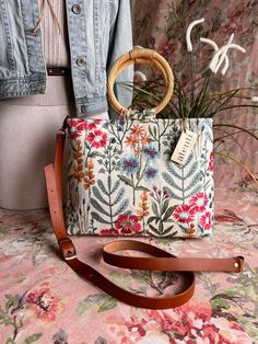 The Atenti Wildflower Tall Fifi is adorned with beautifully embroidered spring flowers on a heavy duck canvas and is sure to become a new, fresh favorite. Stow away all your essentials and hit the town!  Crafted with the utmost care and attention to detail, this bag is sure to make a statement wherever you go. The Tall Fifi has a chic silhouette - compact but roomy with round straw handles and a cream denim interior.

Atenti's Tall Fifi Wildflower Handbag is a taller version of Atenti Fifi. Your Circular Needle Case, French Market Bag, Christmas Stocking Kits, Tool Pouch, Duck Canvas, Knitting Kits, Crochet Kit, Light Tan, Market Bag